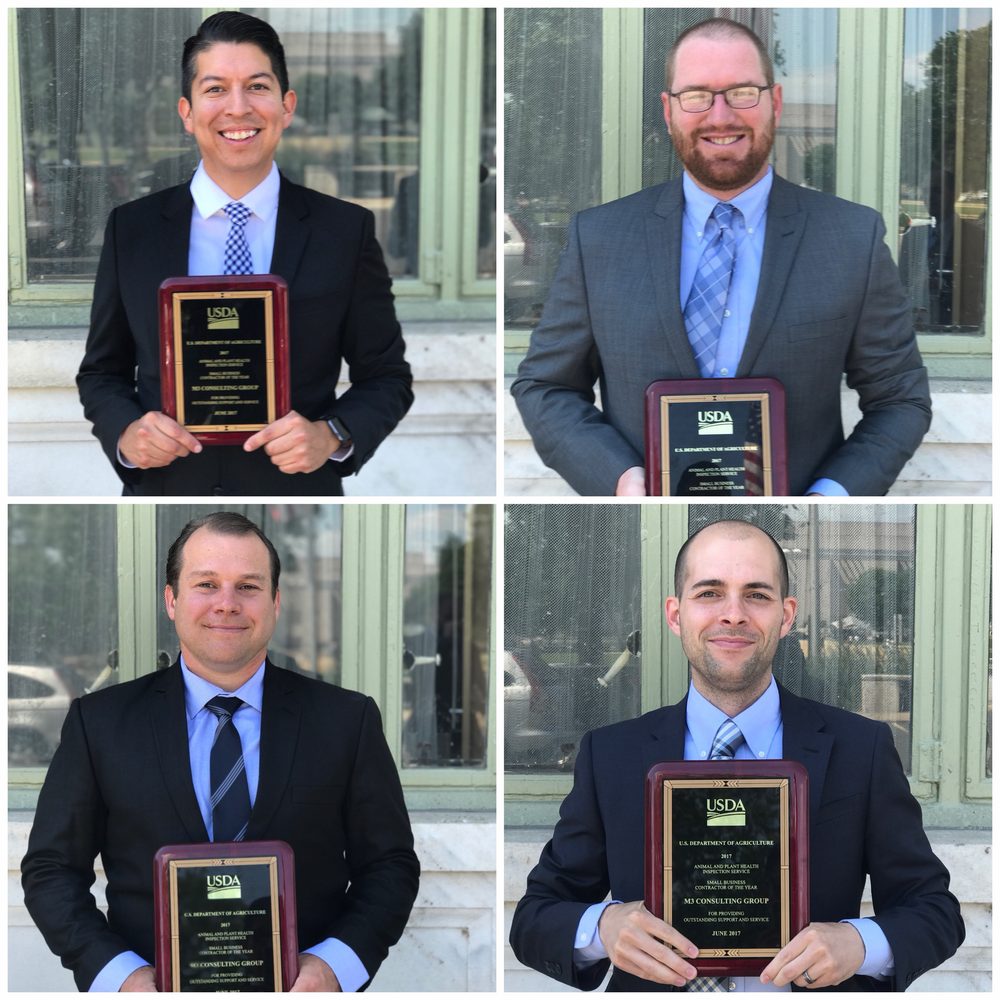 Nathan Moses-Gonzales, Michael Milam, Dustin Krompetz, and Rob Mahrt, each holding the 2017 USDA APHIS Small Business Contractor of the Year plaque